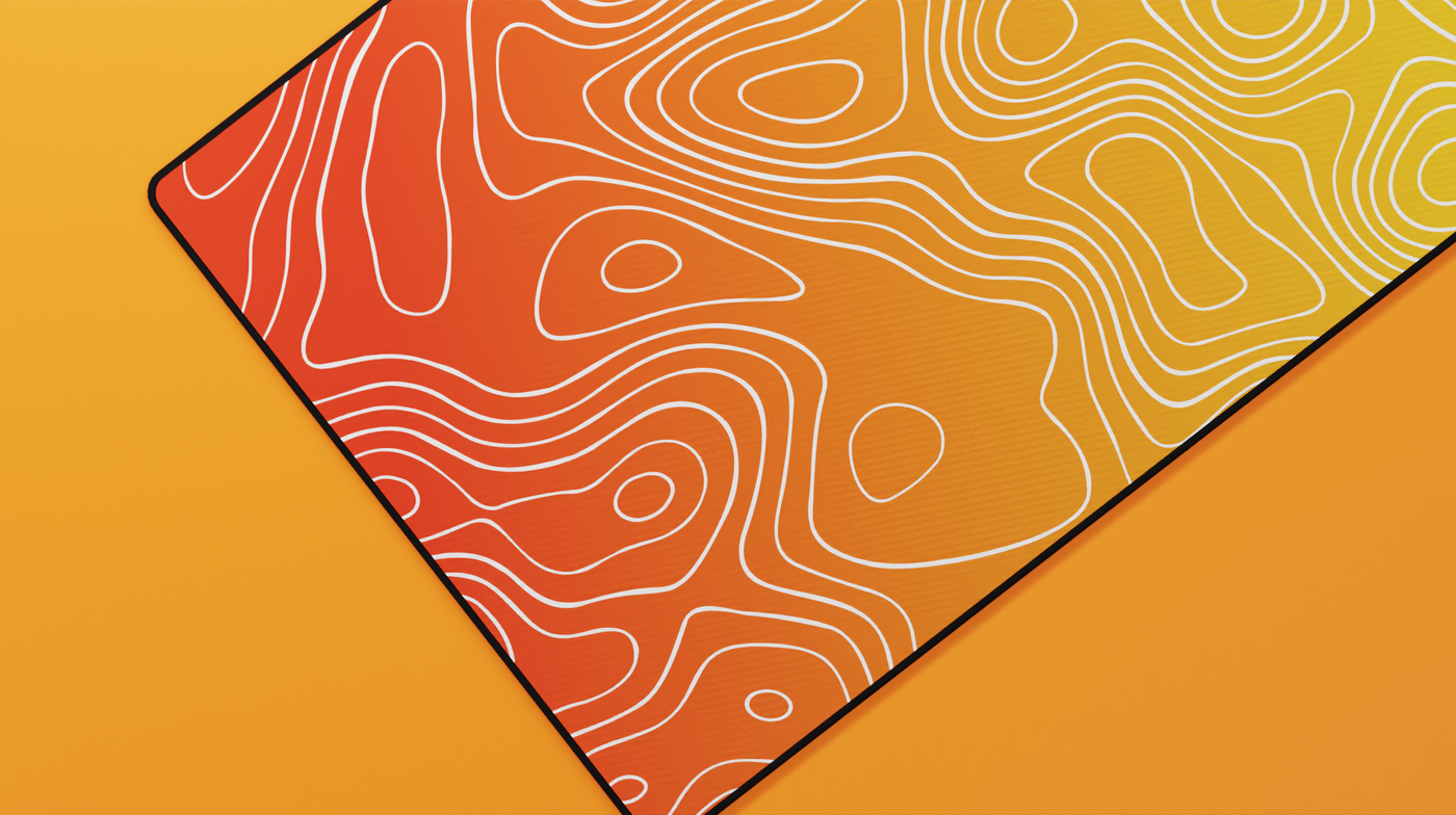 Close-up of the left side of the Amber Topography Deskmat featuring vibrant orange tones, precise stitching, and soft neoprene texture.