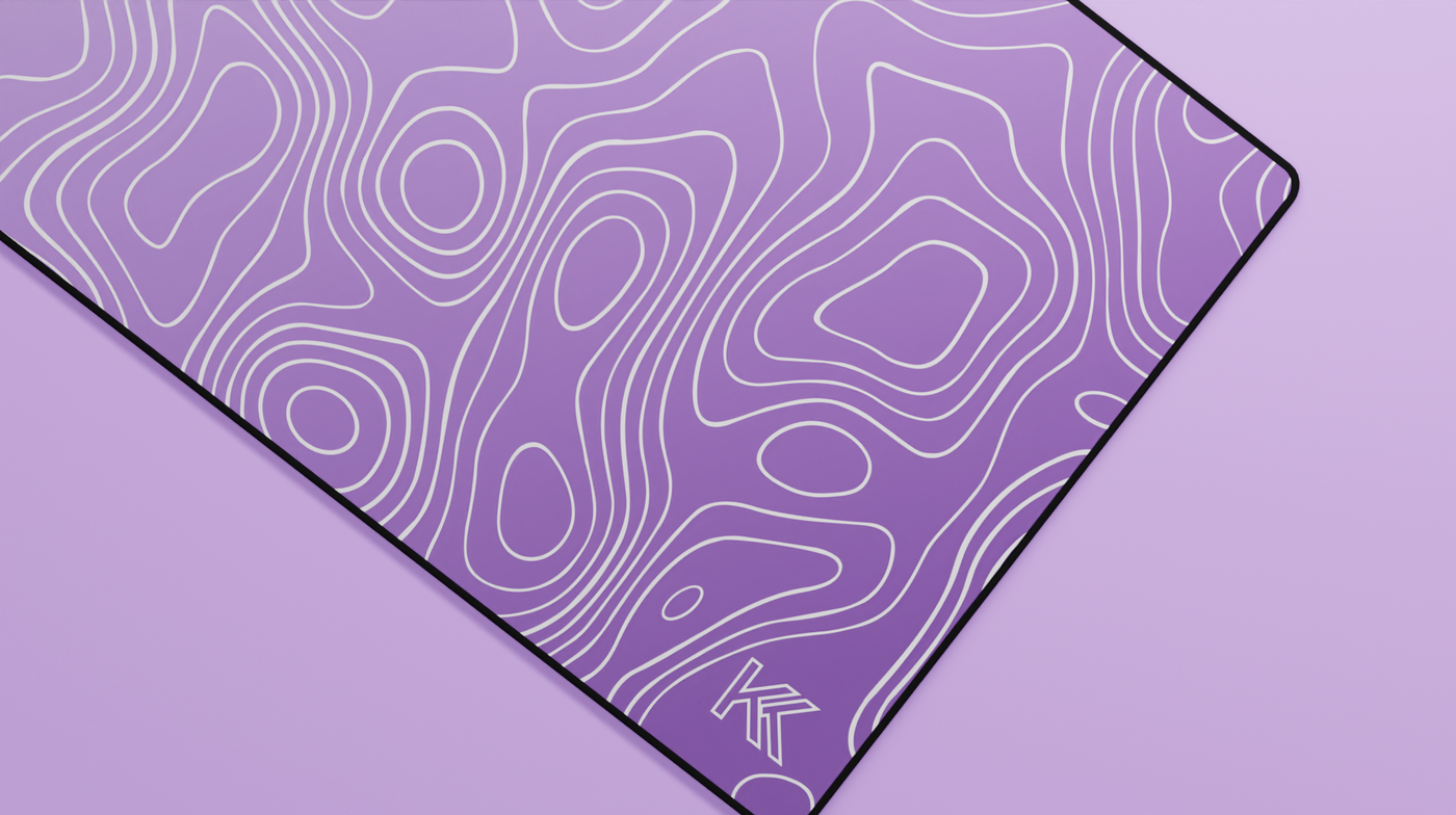 Close-up of the right side of the Amethyst Topography Deskmat showing lighter lilac hues, smooth neoprene texture, and precise hemmed stitching.