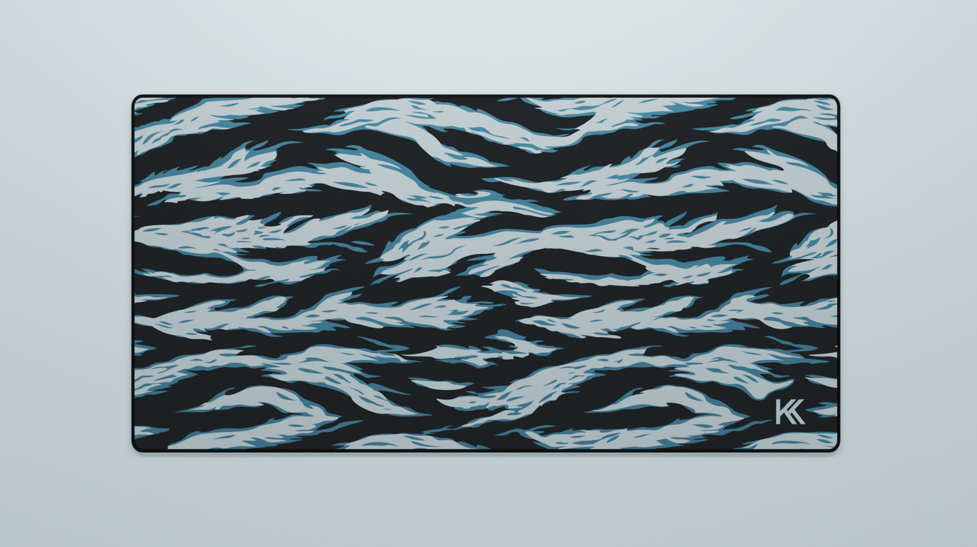 Full view of the Avalanche Tiger Camo Deskmat showing blueish-teal and dark navy tiger stripe camouflage with hemmed edges.