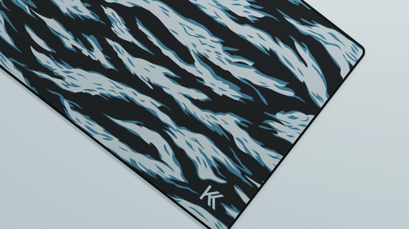 Close-up of the right side of the Avalanche Tiger Camo Deskmat showing bold stripe pattern, hemmed stitching, and surface texture.