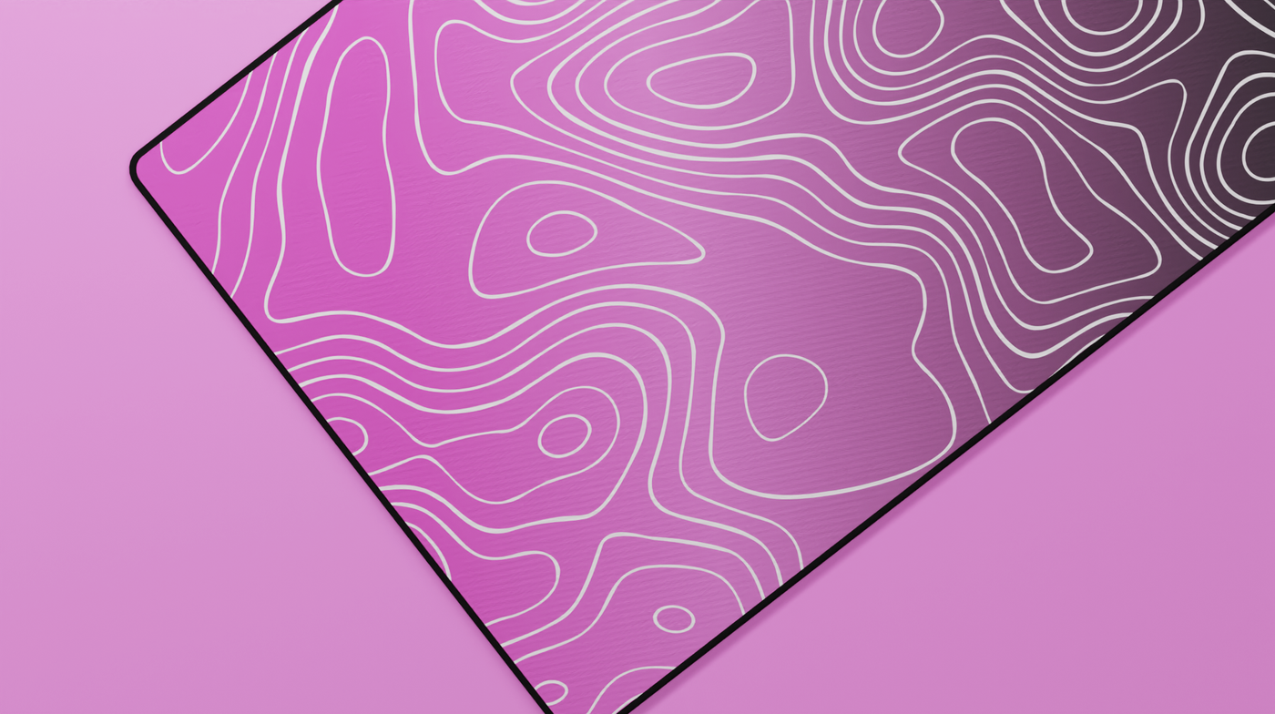 Close-up of the left side of the Blink Topography Deskmat highlighting soft pink tones, detailed topographic lines, and stitched edge texture.