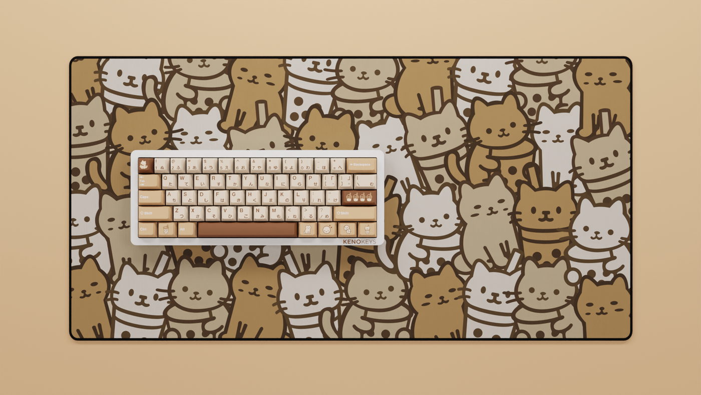 Boba Cat Keycap Set displayed on a 60% keyboard with a matching deskmat, featuring cat and boba-themed novelties in soft brown and cream tones for a cozy café-inspired setup.