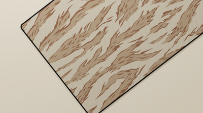 Close-up of the left side of the Desert Tiger Camo Deskmat highlighting beige and brown tiger stripes and smooth neoprene surface.
