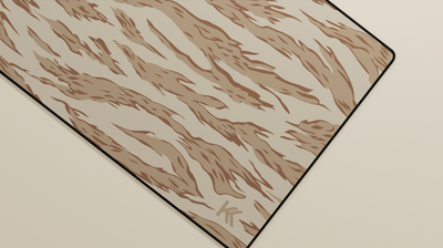 Close-up of the right side of the Desert Tiger Camo Deskmat showing bold stripe pattern, hemmed stitching, and surface texture.