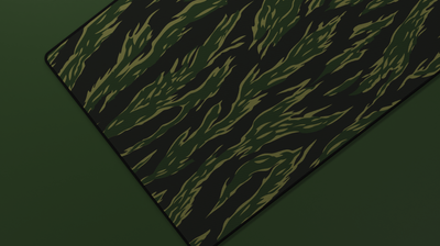 Close-up of the left side of the Forest Tiger Camo Deskmat highlighting deep green tiger stripes and smooth neoprene texture.