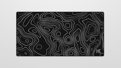 Full view of the Obsidian Topography Deskmat featuring a black terrain design with subtle gray contour lines and neatly hemmed black edges.