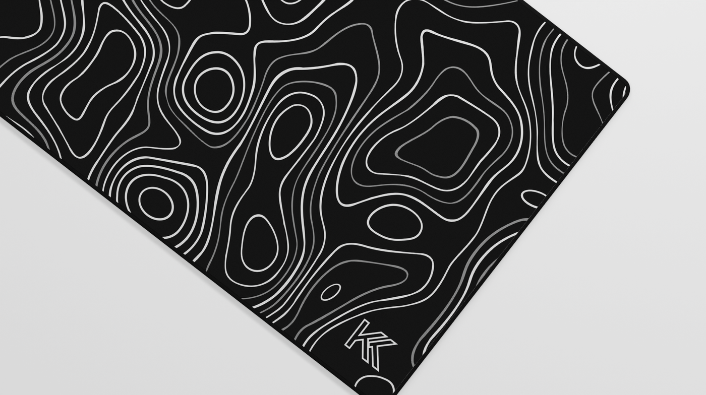 Close-up of the right side of the Obsidian Topography Deskmat highlighting subtle contrast between dark tones, soft surface texture, and hemmed stitching.