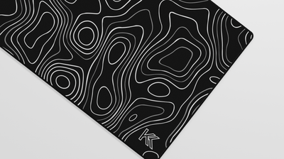 Close-up of the right side of the Obsidian Topography Deskmat highlighting subtle contrast between dark tones, soft surface texture, and hemmed stitching.