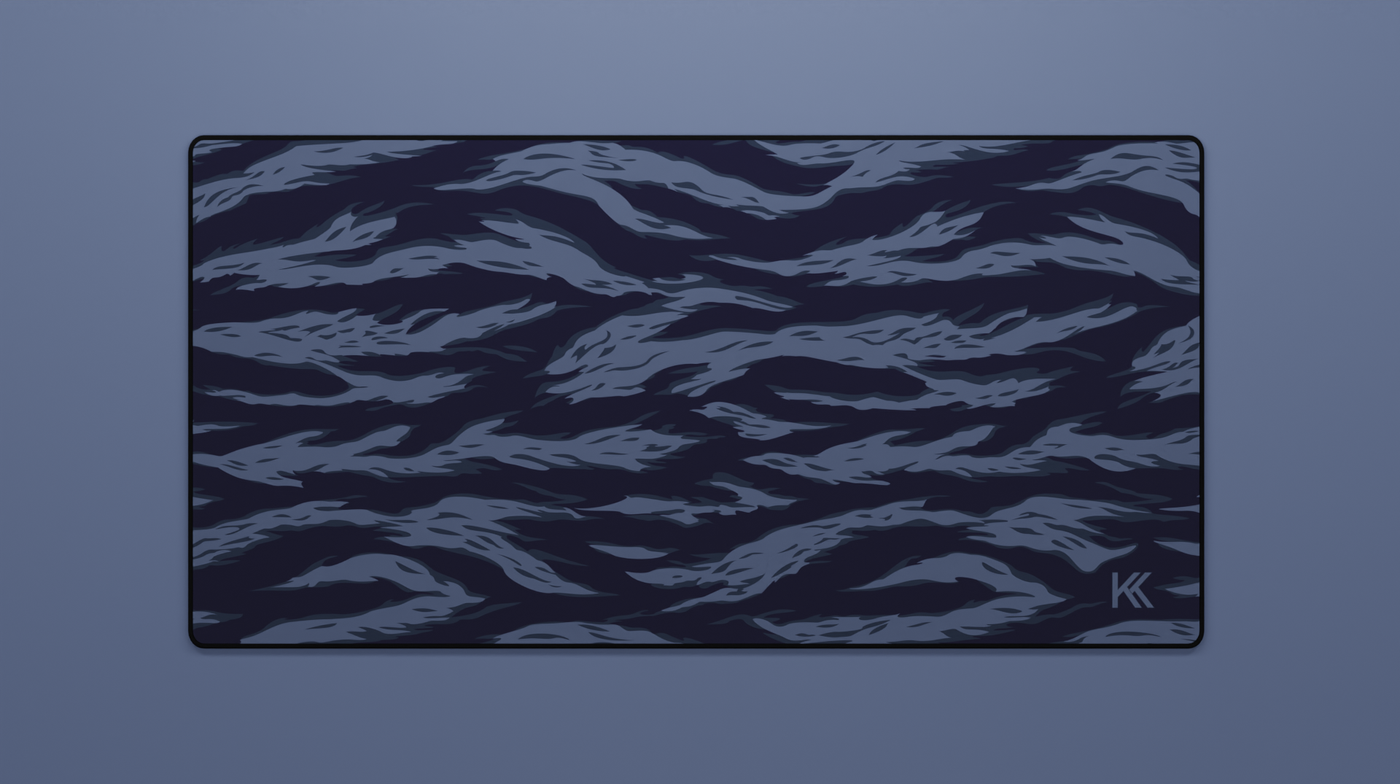 Full view of the Ocean Tiger Camo Deskmat showing deep blue tiger stripe camouflage with hemmed edges.