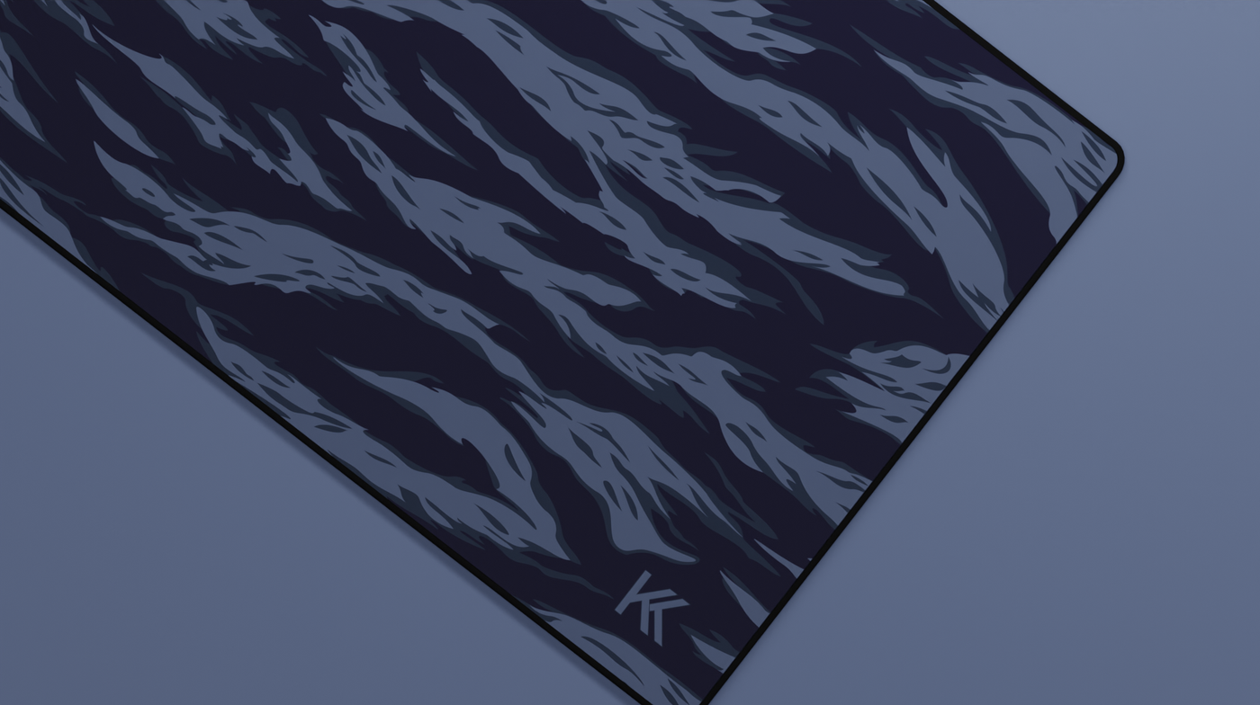 Close-up of the right side of the Ocean Tiger Camo Deskmat showing bold stripe pattern, hemmed stitching, and surface texture.
