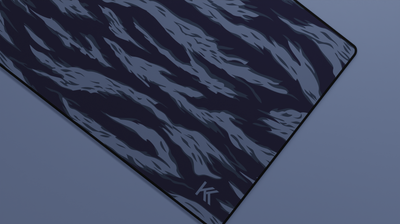 Close-up of the right side of the Ocean Tiger Camo Deskmat showing bold stripe pattern, hemmed stitching, and surface texture.