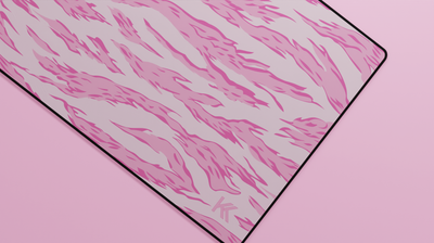 Close-up of the right side of the Pink Tiger Camo Deskmat showing bold stripe pattern, hemmed stitching, and surface texture.