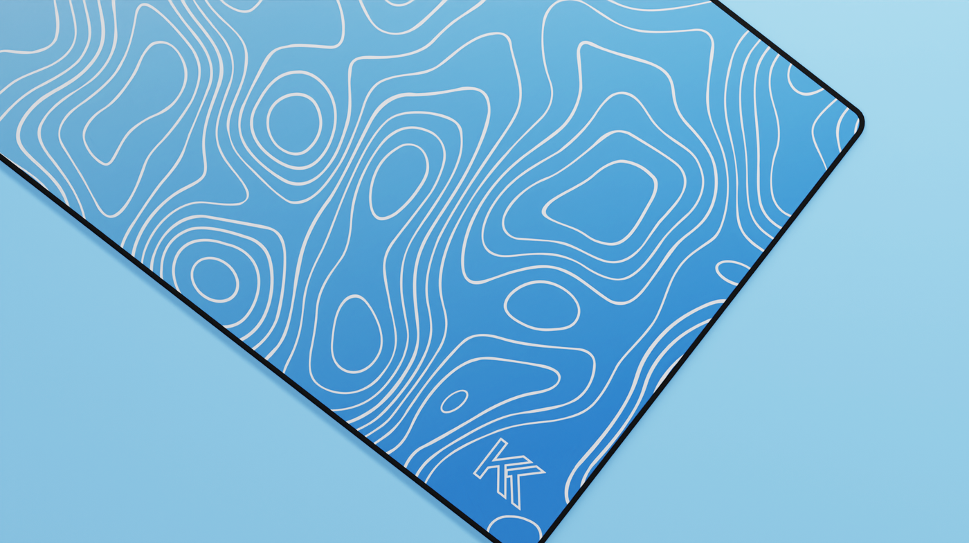 Close-up of the right side of the Sapphire Topography Deskmat showcasing rich blue tones, smooth neoprene texture, and precise hemmed stitching.