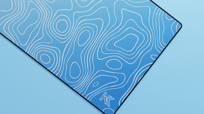 Close-up of the right side of the Sapphire Topography Deskmat showcasing rich blue tones, smooth neoprene texture, and precise hemmed stitching.