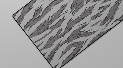 Close-up of the left side of the Winter Tiger Camo Deskmat highlighting grey tiger stripes and smooth neoprene surface.