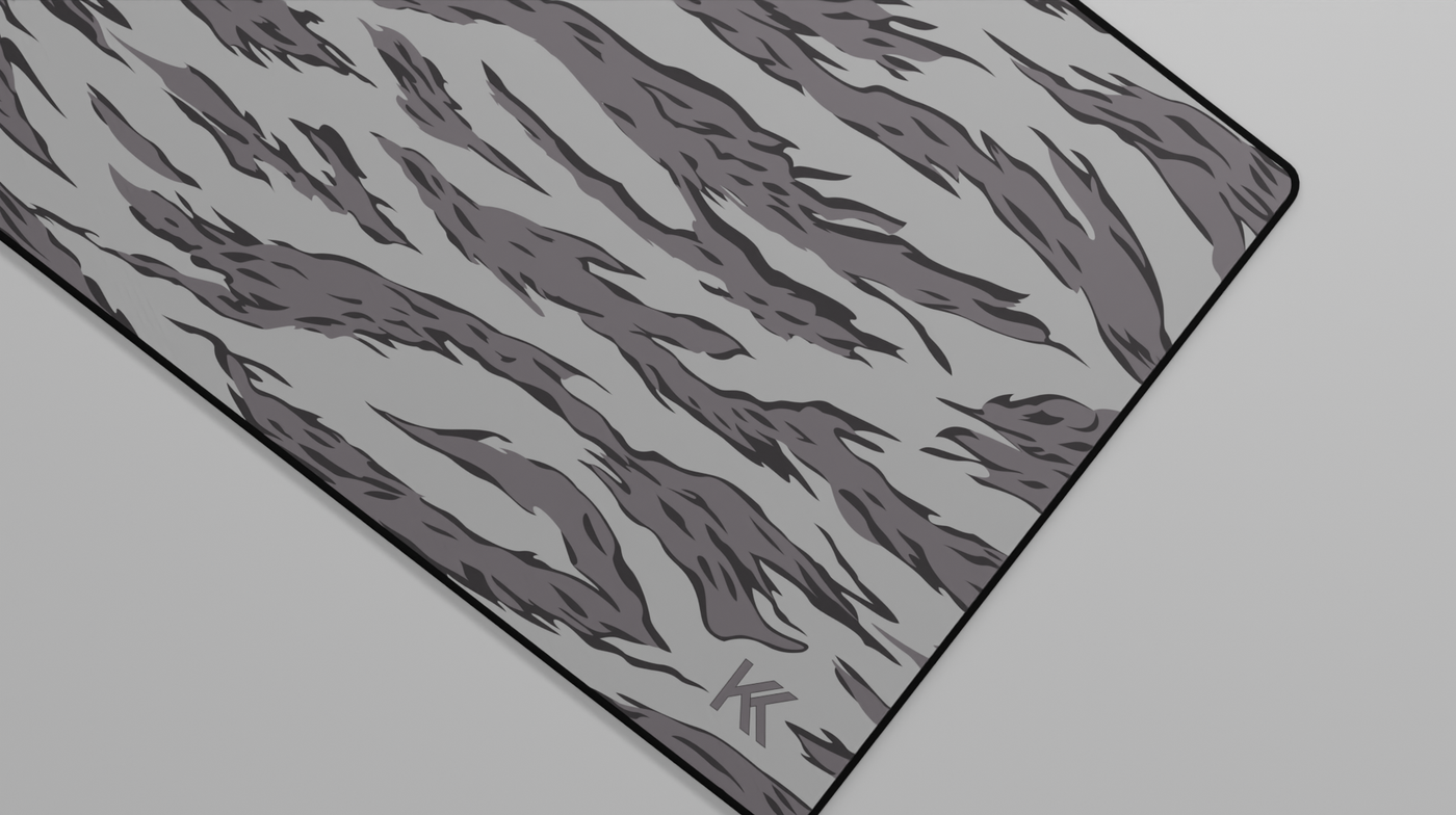 Close-up of the right side of the Winter Tiger Camo Deskmat showing bold stripe pattern, hemmed stitching, and surface texture.